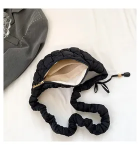 Close-up of black quilted puffer bag showing interior lining and scrunchie strap.