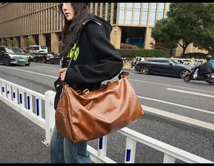 Large brown vintage PU leather travel duffel bag with shoe compartment shown in use