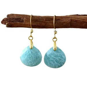 Elegant light blue teardrop natural stone drop earrings with gold hooks on wooden branch