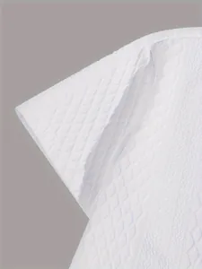 Detailed close-up of white textured knit short sleeve shirt with diamond jacquard