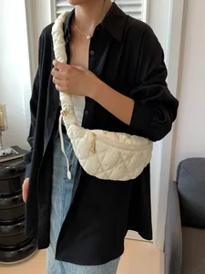 Stylish white puffy quilted cloud bag with drawstring strap worn as a crossbody chest bag.