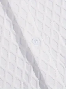 Macro view of premium white jacquard knit fabric on a men's casual short sleeve shirt.
