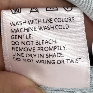 Detailed garment care label showing washing and drying instructions for clothing