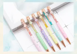 Detailed view of six colorful crystal ballpoint pens with four-leaf clover clips.