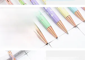 Close-up detail of colorful ballpoint pens with clover motifs and rose gold nibs