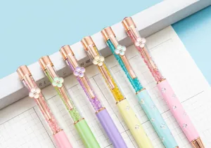 Close-up detail of elegant crystal ballpoint pens with rose gold four-leaf clover clips.