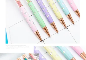 Macro view of elegant pastel four-leaf clover crystal ballpoint pens with rose gold tips