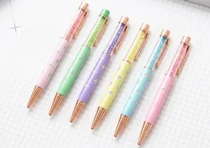 Macro view of elegant pastel four-leaf clover crystal ballpoint pens with rose gold tips