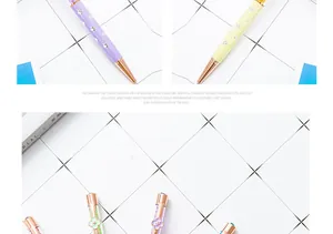 Detailed view of elegant four-leaf clover crystal ballpoint pens on a grid background.