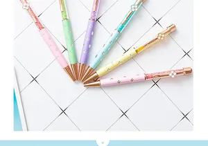 Detailed macro view of colorful crystal ballpoint pens with four-leaf clover charms