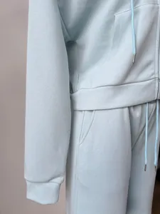 Detailed macro shot of light blue oversized zip-up hoodie and sweatpants fabric texture