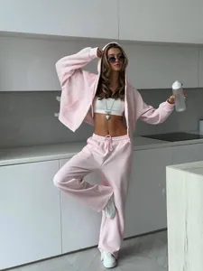 Model wearing baby pink oversized hoodie and jogger set in a modern kitchen