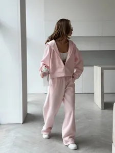 Full length view of pink oversized tracksuit set for women in a minimalist room