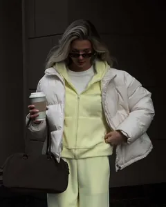 Women's pastel yellow zip-up hoodie tracksuit paired with a cozy white puffer jacket