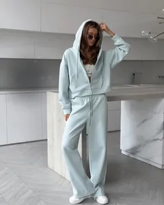 Close-up detail of mint green zip-up hoodie and matching loose sweatpants set for women.