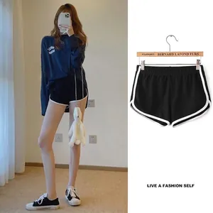 Detail view of black yoga shorts with white contrast trim and elastic waistband.