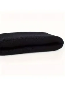 Detailed macro view showing the soft ribbed texture of a black Y2K style knitted beanie