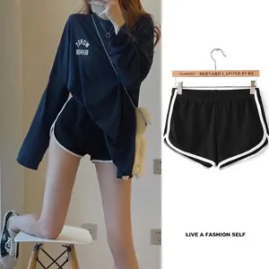 Detailed view of black loose yoga shorts with white piping and elastic waist