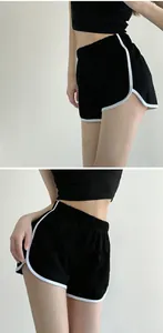 Close-up of women's black yoga shorts with white contrast piping and elastic waist