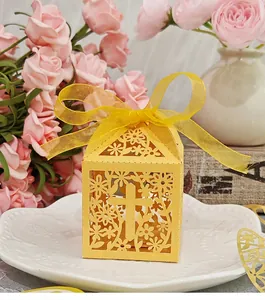 Detail of yellow hollow-out wedding candy box with elegant cross pattern and ribbon