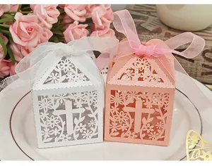 Detail of laser-cut cross and flower pattern on white and pink candy boxes.
