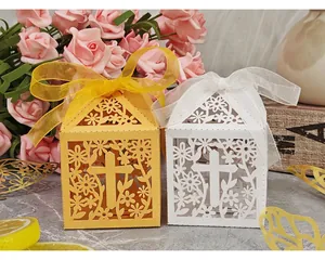 Detailed view of laser-cut hollow gift boxes with floral and cross motifs and silk ribbon.