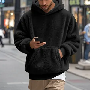 Détail d'un sweat à capuche oversize en polaire sherpa noire pour homme de style streetwear.