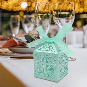 Elegant laser-cut mint green favor box with floral and cross patterns for candy