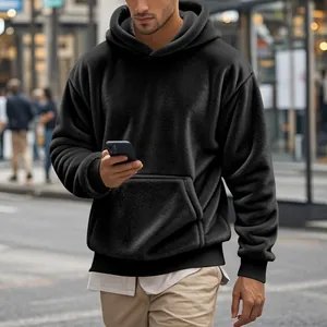Détail d'un sweat à capuche en polaire noire pour homme avec poche kangourou avant