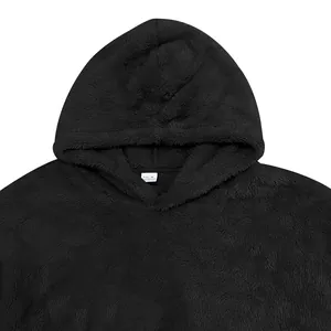 Détail en gros plan sur la texture douce du sweat à capuche noir en polaire sherpa.
