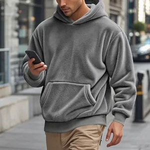 Gros plan d'un sweat à capuche gris en polaire pour homme, texture douce et style.