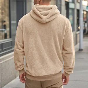 Vue arrière d'un sweat à capuche en polaire beige surdimensionné pour homme en extérieur.