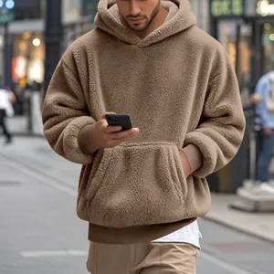 Détail d'un sweat à capuche en polaire marron oversize pour homme dans un style urbain