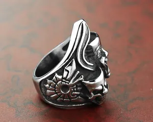 Gros plan sur les sculptures détaillées de masques de clown sur la bague en acier vintage.
