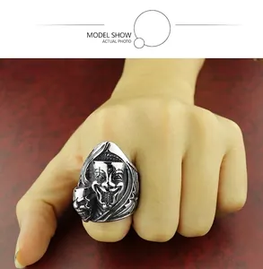 Détail de la bague vintage en acier avec masque de clown et crâne sur une main