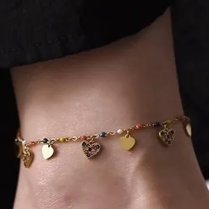 Detailed close-up view of a dainty golden anklet featuring colorful beads and heart charms