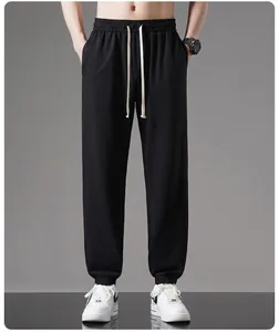 Detail of men's black cotton joggers with elastic drawstring waist and cuffs
