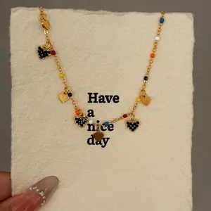 Elegant gold chain anklet with colorful beads and shimmering black heart charms