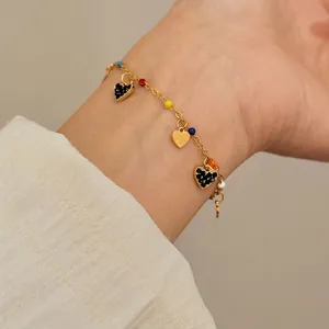 Elegant gold-toned bracelet with colorful beads and sparkling black crystal heart charms