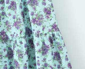 Detailansicht eines hellblauen Blumenrocks mit lila Mustern und gestuften Rüschen
