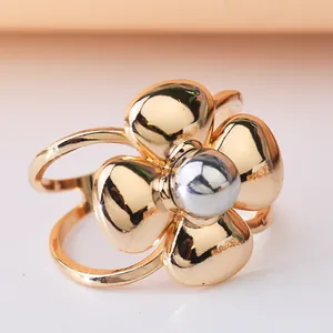 Detailed view of a metallic gold flower-shaped scarf and belt buckle with a silver center.