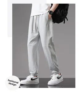 Close-up detail of light grey men's cotton joggers with elastic cuffs