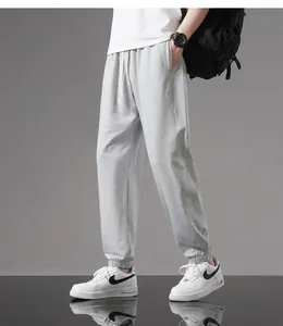 Close-up detail of light grey men's cotton joggers with elastic cuffs