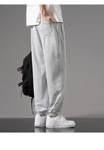 Detail of grey men's cotton sweatpants showing loose fit and cuffed ankles