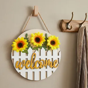 Detail of wooden welcome sign featuring sunflowers and a white picket fence.