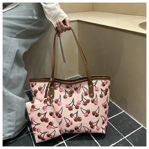 Vue détaillée d'un sac cabas rose élégant à imprimé cerises avec petite pochette.