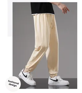 Side view of men's loose beige cotton joggers with elasticized cuffs for casual wear