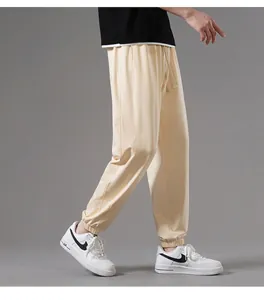 Side view of men's loose beige cotton joggers with elasticized cuffs for casual wear