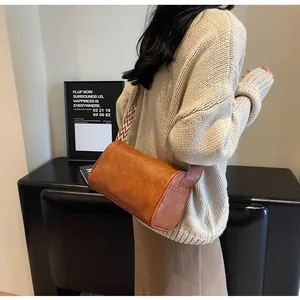 Vintage brown faux leather pillow bag featuring a stylish chevron pattern wide strap detail