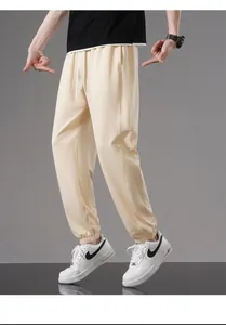 Detailed look at stylish men's loose beige cotton jogger pants for summer wear